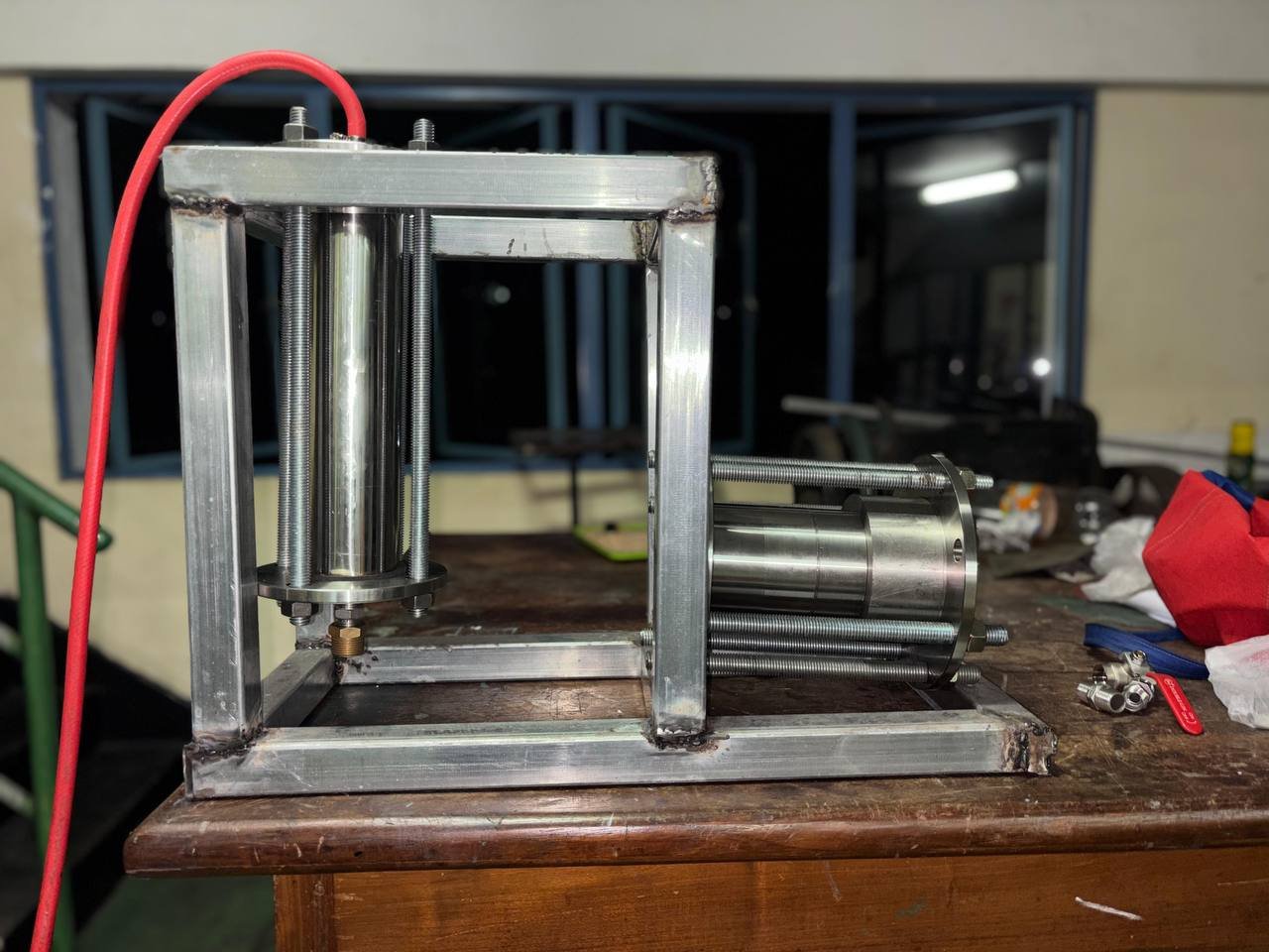 Side view of the engine assembly and vertical vessel inside the support frame
