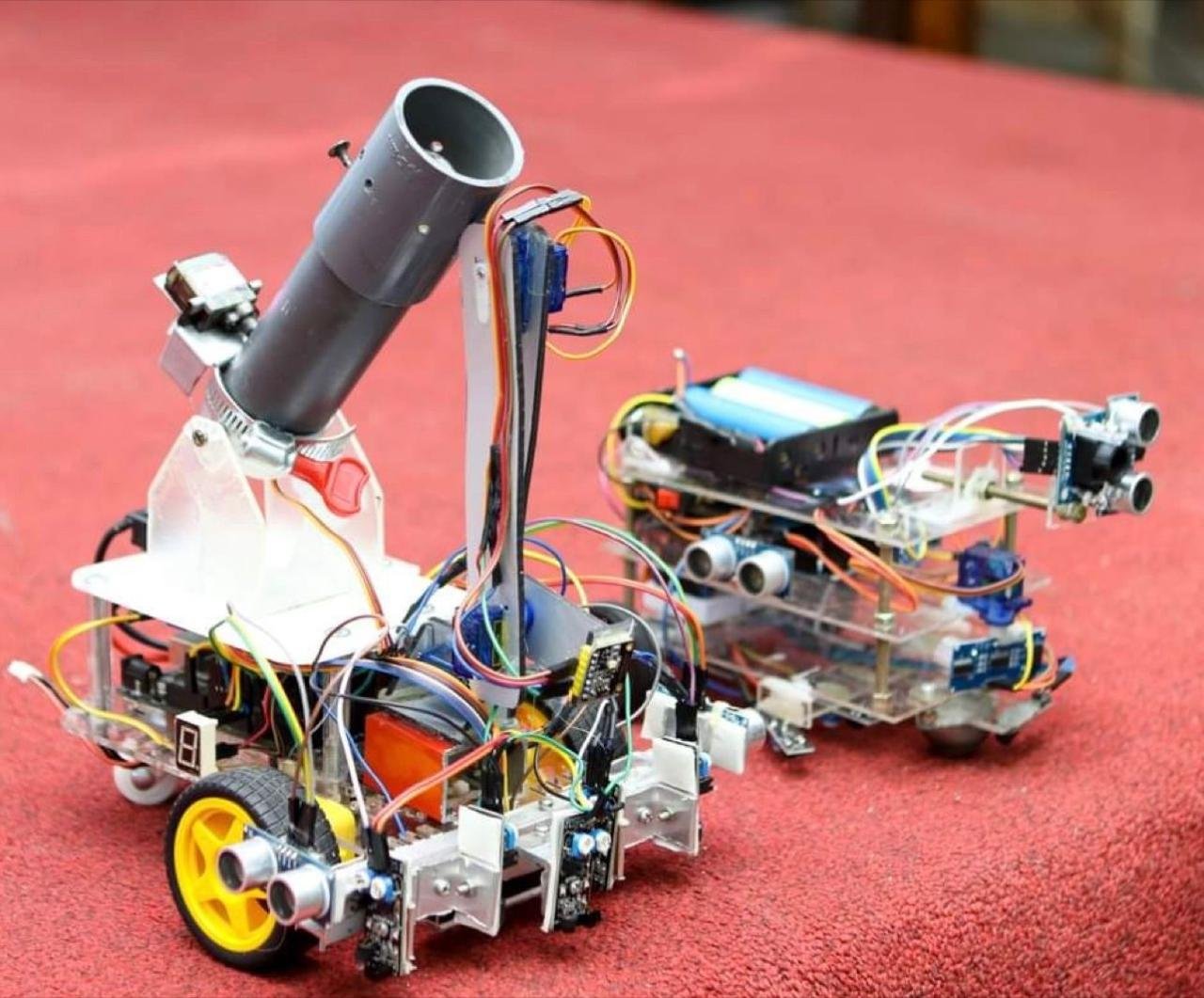 Two built XBOTIX robot platforms with layered chassis, wheels, ultrasonic sensors and task mechanisms